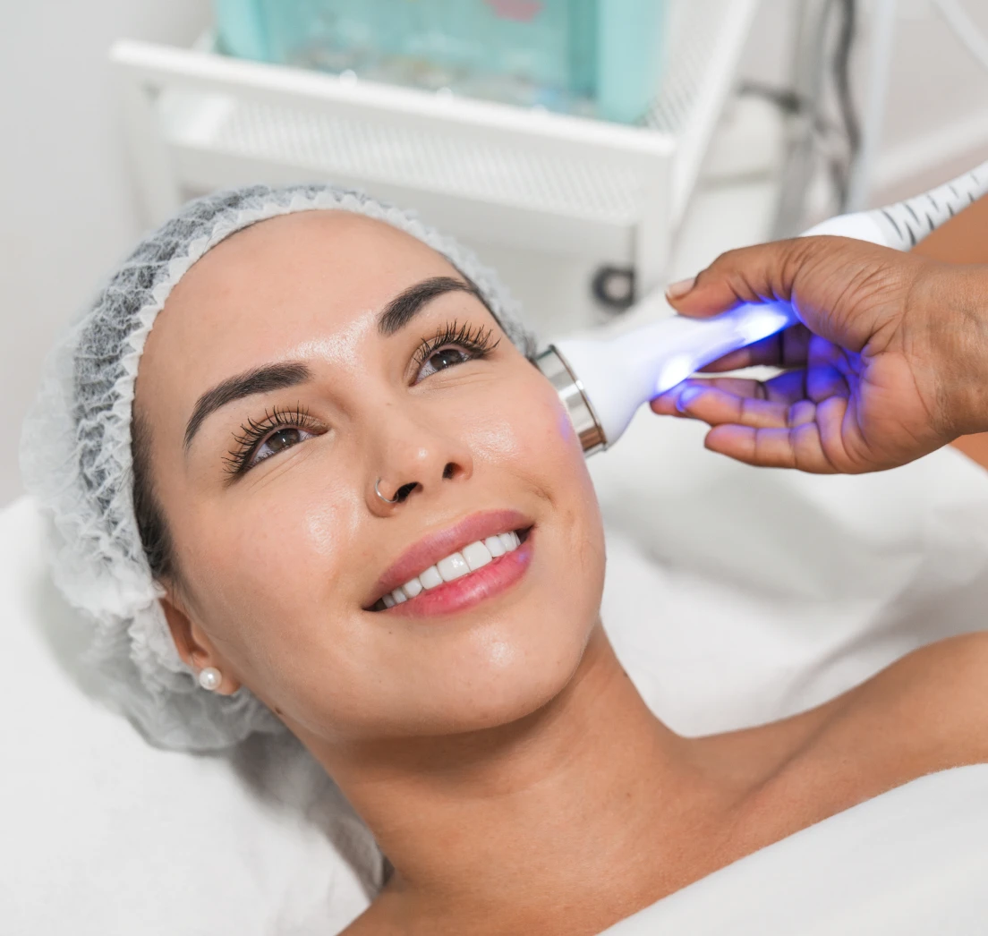 Woman receiving facial treatment with device